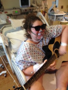 Tt playing the guitar she received for Christmas during her last hospital stay.